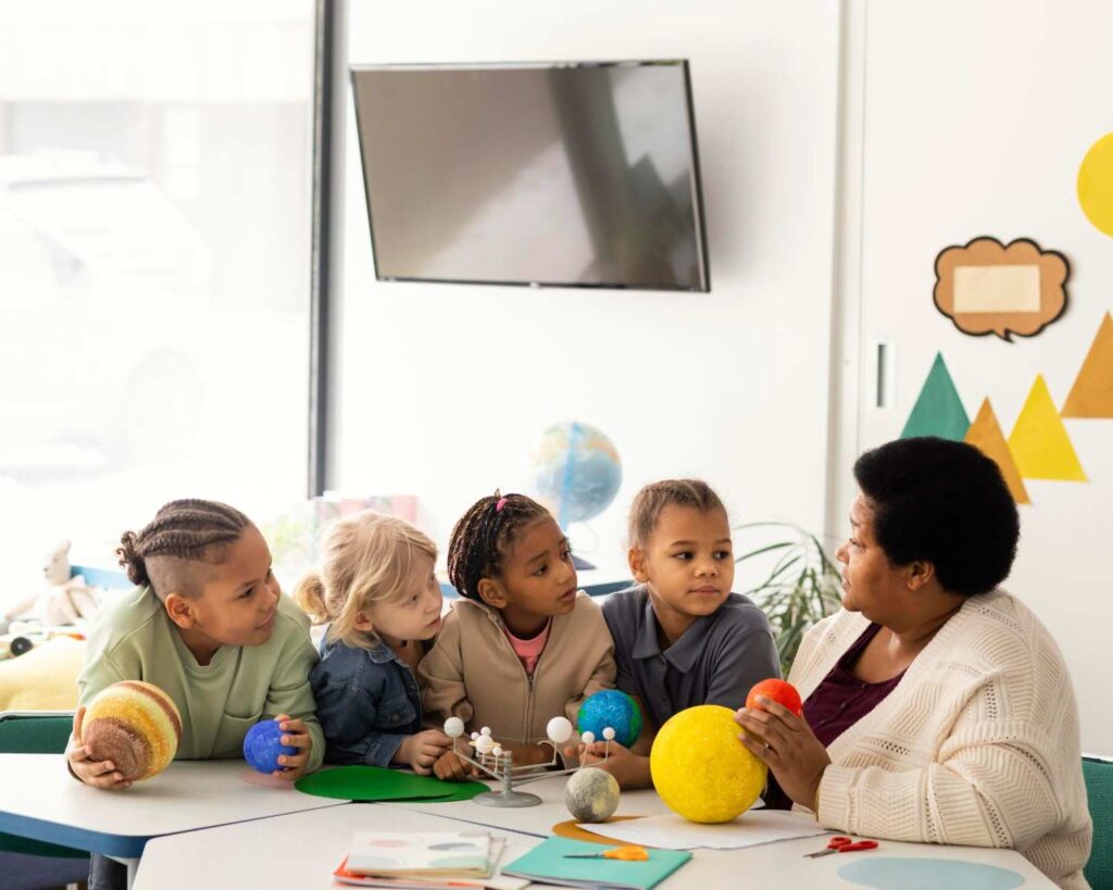 Nigerian teacher engaging toddlers in creative learning activities