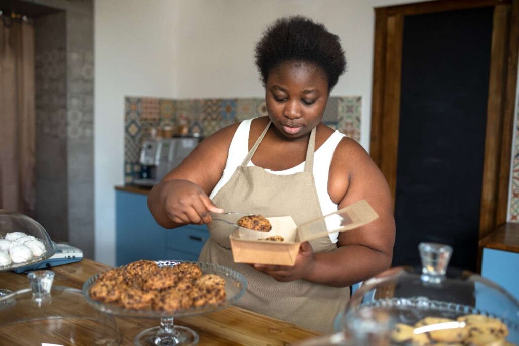 Restaurant owner preparing takeaway food while delivery rider waits
