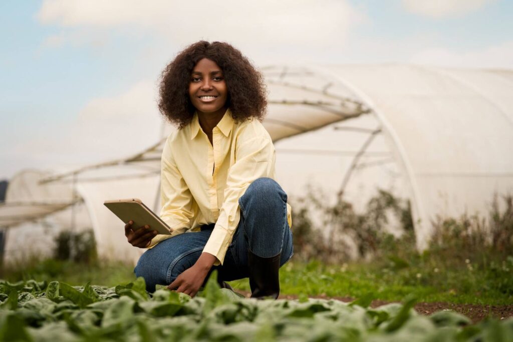 Young Nigerian farmer monitoring crops in a greenhouse — an example of a profitable business in Nigeria for 2025