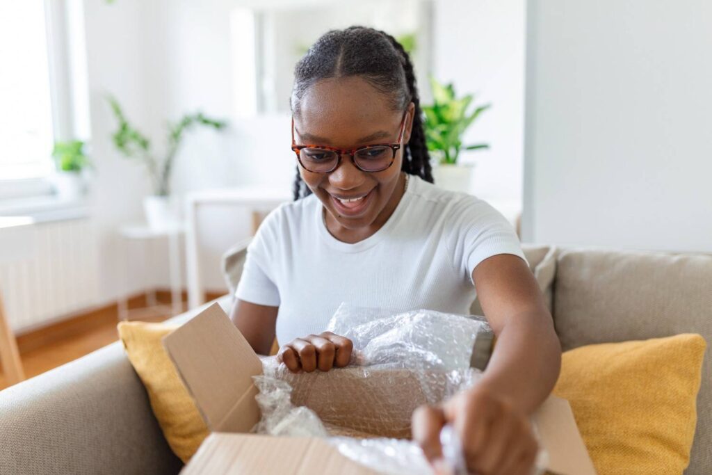 Nigerian youth unboxing mini importation goods in Lagos home-based office